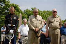 Photo of uniformed military personnel with hands clasped in front of them with bowed heads